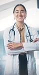 Arms crossed, face and smile with doctor in hospital for health or medical wellness. Confidence, friendly and trust with happy woman in clinic for appointment, consulting or healthcare checkup
