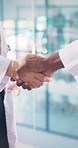 Doctor, people and handshake in hospital with teamwork, collaboration and agreement for healthcare. Medical coworkers, shaking hands and partnership in clinic with deal, approval and cooperation.