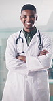 Arms crossed, black man and face of doctor in hospital for health or medical wellness. Confidence, consulting and trust with happy healthcare professional in clinic for appointment or checkup