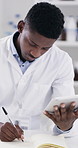 Notebook, tablet and scientist in laboratory with writing for medical research in science. Black man, digital technology and African biologist with notes for pharmaceutical development with study.