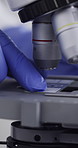 Hands, scientist and slide in lab with microscope, research and medical study for experiment. Person, glass and biotechnology for liquid testing, specimen analysis and machine for vaccine development