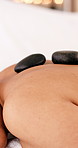 Woman, relax or hot stone therapy with massage bed for spa, body treatment or vacation in salon. Mature person, rest and resort for holiday wellness with holistic healing, zen or beauty session