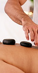 People, hands or hot stone therapy with massage bed for spa, body treatment or vacation in salon. Mature woman, relax and resort for holiday wellness with holistic healing, zen or beauty session