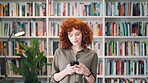 Bookshelf, education and phone with student woman in library for development, learning or research. College, scholarship or university with person typing on campus for information, knowledge or study