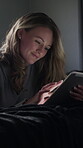 Woman, online and smile with tablet on bed, relax or scroll ebook on web with subscription at night. Happy person, home and reading novel with tech in dark bedroom, rest and entertainment on break
