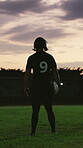 Football player, fitness and person with ball on field, back and training for sport match and health. Evening, exercise and athlete on grass for practice, wellness and preparing for game outdoor