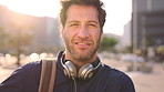Creative, face and businessman with backpack in city, commute and pride for music production career. Outdoor, sound engineer and happy person with headphones, travel and employee with smile in USA