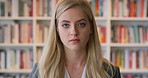 Girl, face and student in library for education at college by bookshelf, confidence or pride at campus. Woman, literature and portrait for learning, research and serious at university in Australia