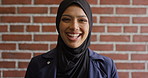 Face, laughing and learning with Muslim woman on brick wall background at college campus. Belief, education and faith with funny student at university for Arabic, Islamic or religious studies