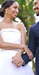 Happy, couple and holding hands in park for wedding ceremony, love or walking with partner in nature. Outdoor, romance and people with marriage commitment, bride and celebration with groom in garden