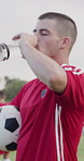 Drinking, water and man on soccer field, fitness and hydration after practice and match preparation. Outdoor, athlete and person with mineral on break, thirsty and cool down with liquid or wellness