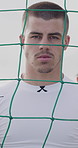 Soccer, sports and face of man by net for playing game, training and practice for match. Athlete, goalkeeper and portrait of serious person by goalpost for exercise, challenge and fitness outdoor
