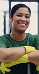 Janitor, woman and face in office with arms crossed, hygiene service and smile for disinfection. Portrait, gloves and cleaner person for sanitation, maintenance and management for wellness or safety