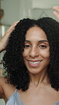 Face, haircare and woman in home bathroom with natural texture, shampoo or hair moisturiser. Happy, curly hairstyle or morning routine of person for self care, wellness and grooming for beauty