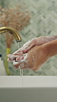 Hands, washing and person in home for hygiene, disinfection and remove dirt for wellness. Cleaning, water and soap with faucet at house for skincare, sanitation and germ protection for grooming habit