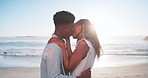 Kiss, care and black couple by beach in holiday, getaway or weekend trip together for bonding. Happy, love and African man with woman for intimate moment in marriage by ocean for seaside vacation.