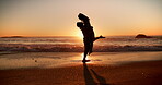 Silhouette, couple and jump in hug on beach for sunset date, romantic holiday and connection. Kiss, evening and people with lifting at seaside for anniversary vacation, healthy relationship and trust