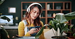 Phone, leaf and check with woman in home for botany app, horticulture research and inspection. Plant identification, gardening tips search and eco friendly hobby with person and headphones in house