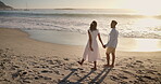 Sunset, black couple and walk on holiday at beach for honeymoon trip, connection or bonding. Sunshine, people or holding hands at seaside for romantic stroll, summer vacation and healthy relationship