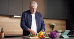 Cutting, recipe and old man with vegetables, cooking and confidence with tablet, home and food. Happy, pensioner and senior person in kitchen, skills and ingredients with meal prep, health and knife