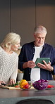 Kitchen, cooking and old couple with tablet, cut vegetables and organic recipe guide in retirement. Tech, senior man and woman with meal prep, chopping board or online tutorial for vegan diet at home