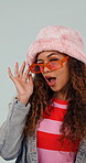 Face, sunglasses and woman in studio, wink and facial expression on white background. Happiness, funky eyewear and person with fashion, stylish clothes and cool with trendy outfit or designer shades