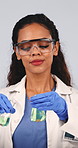 Scientist, inspection and liquid in studio for chemistry, research and medical study with experiment. Woman, goggles and mixture with beaker, chemical reaction and testing sample on white background