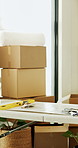 Empty room, house and boxes for renovation with table, real estate and tools for property improvement. New home, remodeling and cardboard container with equipment, refurbishment and rental apartment