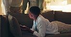 Night, phone and sneaky with black child on sofa in home living room to hide from parents. Late, screen time and social media with discreet boy in apartment for stealthy browsing on mobile app