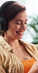 Happy, headphones and woman in home with phone, social media and streaming music on weekend. Typing, sofa and person with audio, podcast and radio on cellphone for connection, contact and break