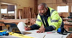 Architect, blueprint and black man with laptop for construction development or architecture design. Male person, contractor or civil engineer writing with documents for building plan in workshop
