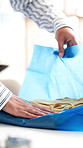Hands, woman and wrapping clothes in store for sale, gift and shipping preparation with textile. Boutique, pack and fold apparel for retail order process, fashion and distribution in small business