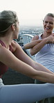 Fitness, friends and women stretching on bridge, training discussion and warm up routine for wellness. City, runner and happy people with workout preparation for health, morning practice and talking