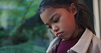 Thinking, sad and child by window in home with reflection of trauma, bad memory and loneliness. House, childhood and girl with thoughtful, wondering and upset emotions for separation, alone and worry