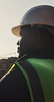 Construction site, engineer and man with helmet for safety, thinking and infrastructure development. Architect, ppe and black person outdoor for planning, project vision or building idea with profile