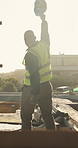 Construction, success or man on site with hardhat, project finish or celebration in building progress. Back, flare or engineer with helmet, deadline complete or achievement in industrial development.