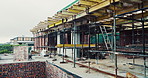 Scaffolding, property and architecture for construction site, development project or home renovation. Brick wall, framework and real estate with house, building and suburban improvement or remodeling