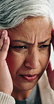 Headache, tired and stress with old woman in home for frustrated, fatigue and brain fog. Migraine pain, worry and temple massage with senior person in living room of house for crisis and overwhelmed