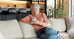 Typing, phone and smile with old woman on sofa for social media, ebook subscription and app. Online library, retirement and senior person in home, tech for communication and message to contact