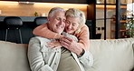 Hug, smile and old couple in home with love, connection or care with relationship security. Living room, happy man and woman embrace on sofa for trust, support and commitment to partner in retirement