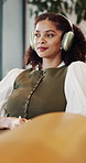 Woman, dance and smile with headphones in lounge, relax and listening to music with app subscription. Streaming, audio and happy person with tech on couch, rest and chilling with radio sound in house