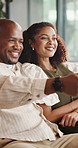 Happy, relax and black couple watching tv in home for bonding, comfort or online entertainment. Man, woman or weekend with smile on sofa for subscription, movie channel or series together in house