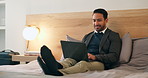 Businessman, relax and typing with laptop in bedroom for remote work, schedule or communication. Man, freelancer or smile with computer in bed for online network, internet or connection in home