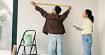 Measure, tape and couple in new house for renovation, maintenance or repairs for property development. Tool, real estate and man with woman for precision on wall for construction in apartment.