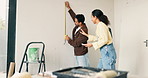 Measure, tape and couple in new home for renovation, maintenance or repairs for property development. Tool, real estate and man with woman for precision on wall for construction in apartment.