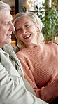 Old couple, relax and talking in home with smile, discussion and bonding together in lounge. Happy, senior people and laugh at house with embrace, funny conversation and retirement for weekend break