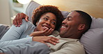 Laugh, relax and black couple on bed in home for watching tv, bonding or joke together on weekend. Happy, talking and man with woman in bedroom for streaming comedy movie with connection at house.