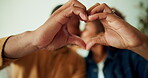  Couple, kiss and hands with heart in house, commitment and love symbol with partner and anniversary. People, bonding and shape with gesture in living room, care and connection with spouse in home