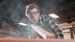 Carpenter, cleaning and blow dust with plank in workshop, furniture manufacturing or production process. Woodwork, man and remove sawdust, craftsmanship and wipe shavings in carpentry industry