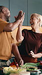 Cooking, funny and high five with interracial couple in kitchen together for diet or healthy eating. Food, laugh and success with mature people at counter in apartment for meal prep or nutrition